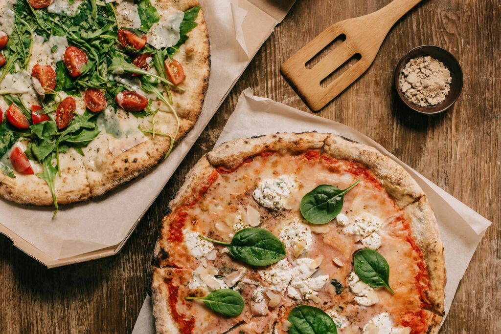 top view of tasty italian pizzas on wooden tabletop