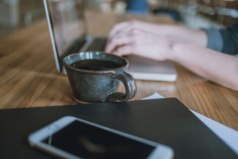 Woman Working on Laptop in a Coffee Shop