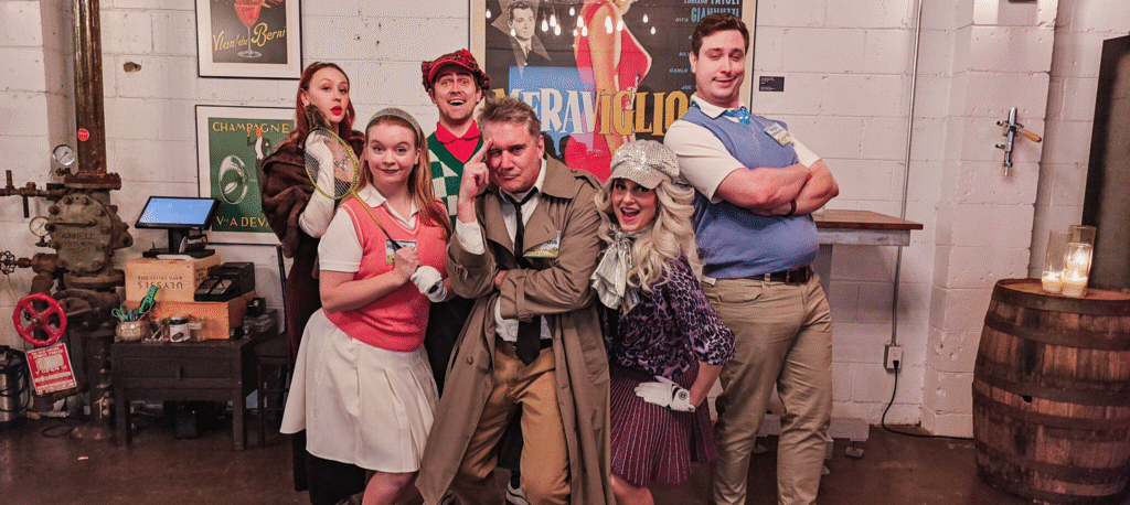 a cast of characters from a murder mystery posing for a photo