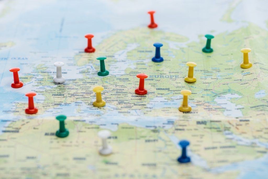 selective focus of colorful push pins on world map